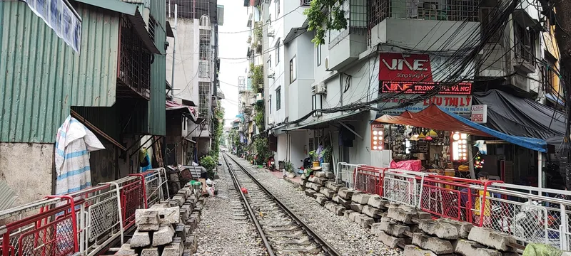 Narrow train tracks run between crowded old houses and cafés on Hanoi's famous Train Street.