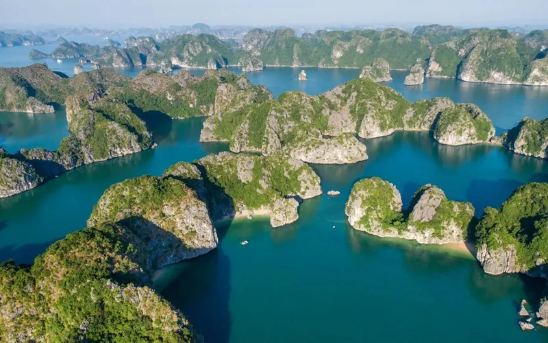 Aerial view of limestone karsts rising from turquoise waters in Lan Ha Bay