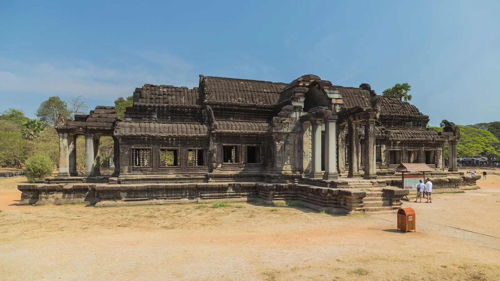 A weathered stone library building with columned porches stands beside Angkor Wat in Siem Reap.