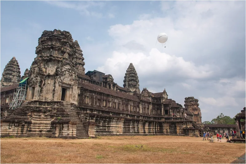 Ancient stone towers of Angkor Wat rise beside a hovering balloon in Siem Reap, Cambodia.