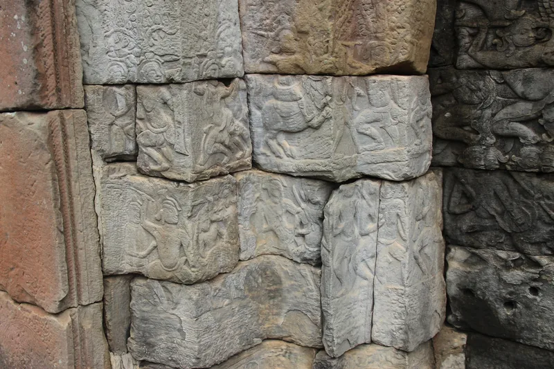 Weathered stone blocks carved with figures decorate a wall at Bayon temple in Angkor Thom, Siem Reap.