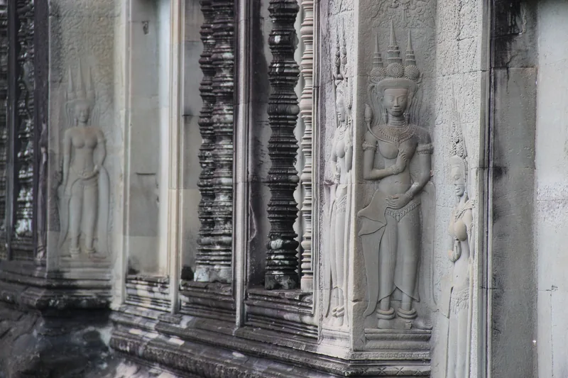 Rows of intricately carved apsara figures adorn a stone wall at Angkor Wat in Siem Reap.